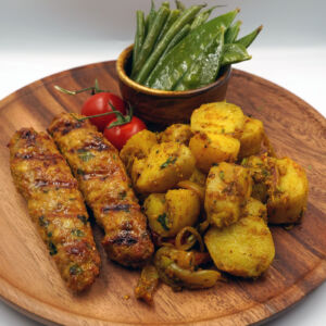 Chicken reshmi kebabs served with spicy baby potatoes and steamed mix greens
