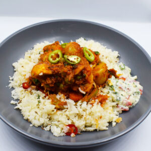 Vegetable curry served with cauliflower rice and yoghurt raita.