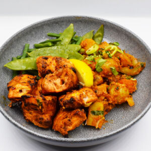Vegetable curry served with Chicken tikka and steamed greens.