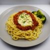 Lamb Bolognese with spaghetti, steamed broccoli, topped with mozzarella cheese.