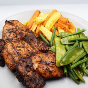Jerk style chicken thighs with  steamed mix greens and oven baked carrot and parsnip chips.